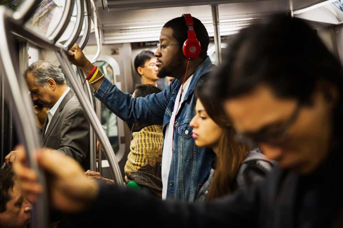 A commuter listens to Beats brand headphones while riding the subway in New York, May 29, 2014.