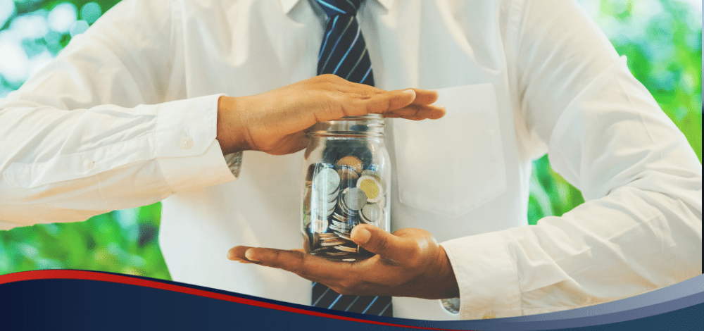 Person holding clear jar with coins