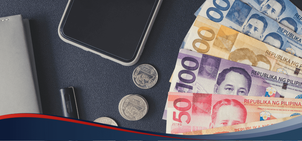 Cellphone, philippine bills and coins on blue platform